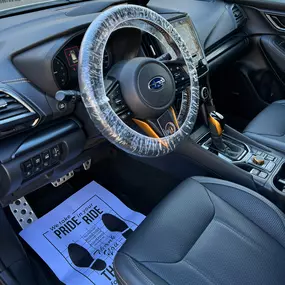 Meticulously cleaned Subaru interior dashboard, seats, and console with protective coverings applied post-detailing.