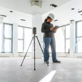Mitarbeiterin von Projekt Kraft beim digitalen 3D-Aufmaß mit Laserscanner und Tablet in einem lichtdurchfluteten Innenausbau-Projekt.