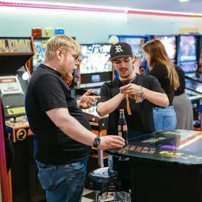 Company owner explaining to one of his valued Gold Band Members, some of the customizations he intends to make on his rare, Pac Man Pixel Bash Bistro Arcade Game.