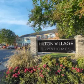 The welcoming community entrance at Hilton Village Townhomes showcases a charming and well-kept neighborhood.