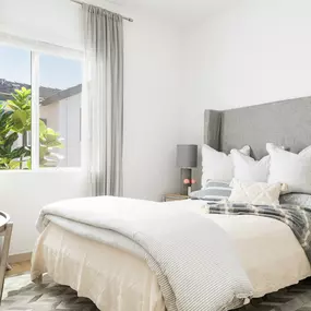 a bedroom with a bed and a window