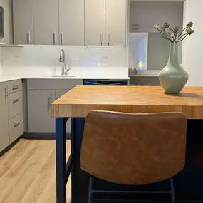 A kitchen with a wooden table and a brown chair