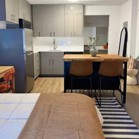 A kitchen with a refrigerator, sink, and cabinets