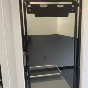 A detailed view of a private dog suite door in Exeter, showing the durable, secure build and see-through design for staff supervision and pet comfort.