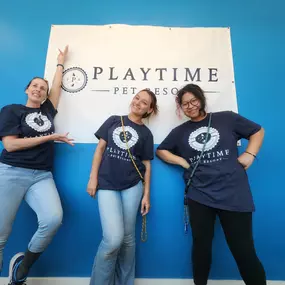 Playtime Pet Resort Windham team members pose proudly in front of the facility’s branded banner, reflecting the friendly and dedicated staff that provide personalized pet care.