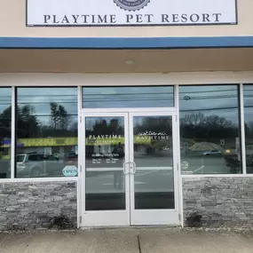 A closer look at the facility’s exterior branding, showing the official Playtime Pet Resort logo and name against a neutral backdrop with bold blue trim.