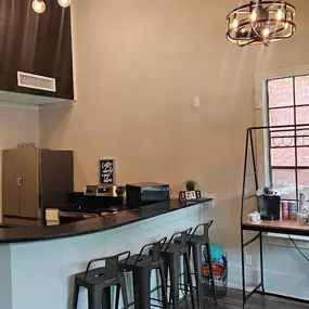 A kitchen with a black counter top and a white wall.