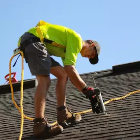 Summit City Roofing technician performing a roof repair on asphalt shingles, ensuring long-lasting protection for Fort Wayne homes.