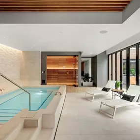 A modern indoor swimming pool with lounge chairs