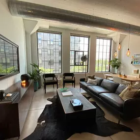 A living room with a black couch and a black rug
