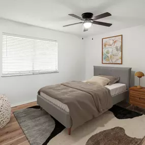 A bedroom with a bed, a ceiling fan, and a rug.