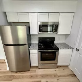 a kitchen with a stove a refrigerator and a microwave