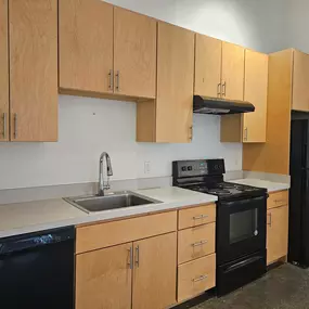 A kitchen with black appliances and wooden cabinets.