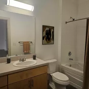 A bathroom with a white sink, toilet, and bathtub.