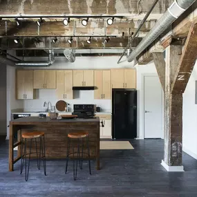 A kitchen with a bar stool in front of it.