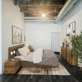 A bedroom with a bed, nightstand, and a plant.