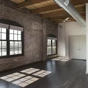 A room with a brick wall and a ceiling fan.