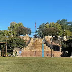 A park with a gazebo, steps, and a flag.
