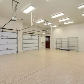 The image shows a spacious garage with two white sectional garage doors and Marantec Model 360, 370, and 380 garage door operators.