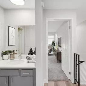 A bathroom with a white countertop and a white sink