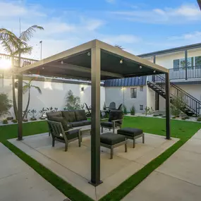 A patio with a table and chairs under a roof.