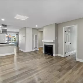 a renovated living room with a fireplace and a kitchen
