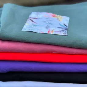 Stack of colorful folded shirts at The Agriculturalist Dispensary in Fall River