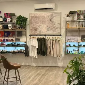 Retail section of The Agriculturalist dispensary in Fall River, featuring neatly displayed apparel, hats, wellness products, and local artwork in a bright, modern setting.
