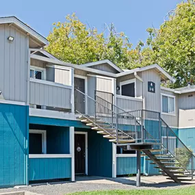 a row of blue condos with stairs and trees