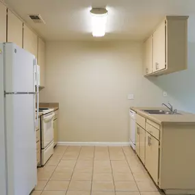 an empty kitchen with a refrigerator and a sink