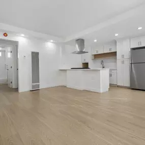 A kitchen with a refrigerator, stove, and cabinets.