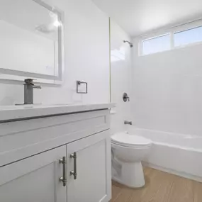 A white bathroom with a toilet, sink, and bathtub.