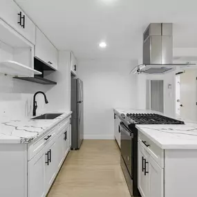 A white kitchen with a black stove top oven.