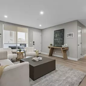 A living room with a couch, coffee table, and a plant.
