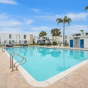 A swimming pool surrounded by palm trees and buildings.
