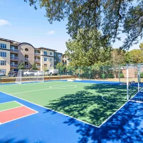 A basketball court with a green surface and a blue background