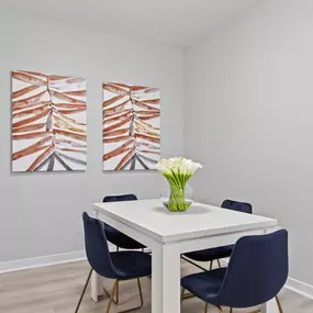 A dining room with a white table and blue chairs