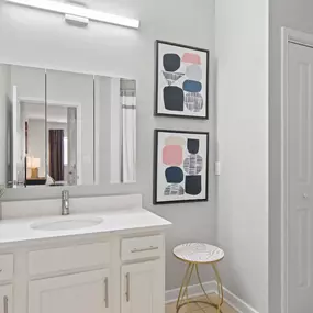 A bathroom with a white sink and a mirror above it