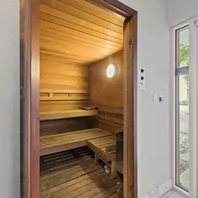 A sauna with wooden walls and benches is open to the outside