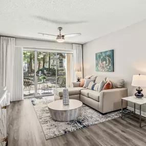 Spacious living room with a rug, table, couch, and ceiling fan