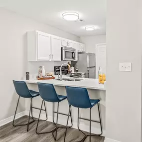Kitchen with eat in island and three blue bar stools