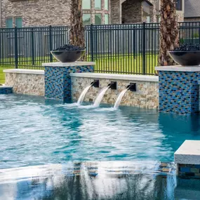 Pool Water features: Scuppers in pools retaining wall and columns with fire bowls