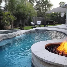Custom hardscaping around pool with fire pit