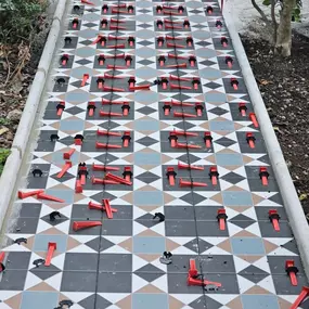 A beautifully aligned geometric tile pathway in progress. This image highlights precision, pattern accuracy, and Ercon’s commitment to exterior aesthetics that blend seamlessly with landscaping.