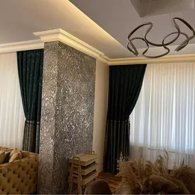 Featuring a textured accent pillar wall, custom crown moulding, and plush curtains, this image showcases Ercon’s attention to detail in interior decor, luxury finishes, and full-room harmony.