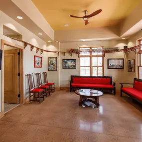 Reception area and waiting room at Dental Depot's Northwest OKC office with red furniture, light colored wood accents, and a model train track.