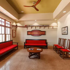 Reception area and waiting room at Dental Depot's Northwest OKC office with red furniture, light colored wood accents, and a model train track.