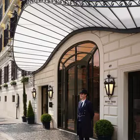 Doorman standing in front of Hotel Eden main entrance