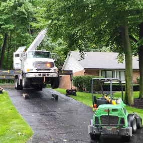 Residential tree trimming with bucket truck and support crew.