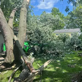 Storm-damaged tree cleanup underway on a suburban property in Novi, MI.